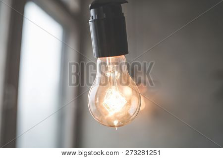 Retro Vintage Light Bulb With Led Technology Bult-in On Warm Light Yellow Tint And Black Background 