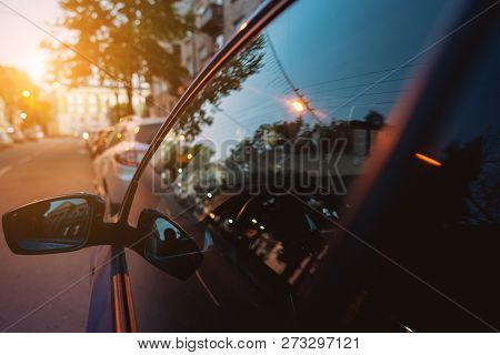 The Side Mirror And The Window Reflect The Street