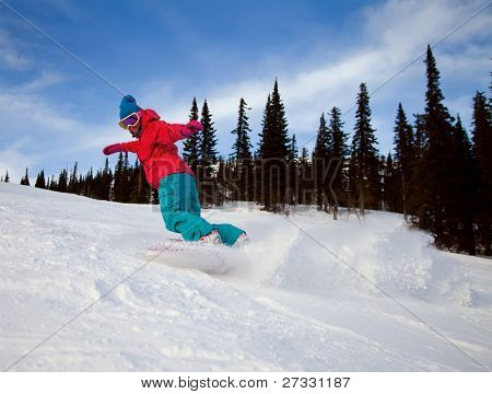 Snowboardista skoky vzduchem s tmavě modrou oblohou v pozadí