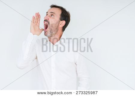 Elegant senior man over isolated background shouting and screaming loud to side with hand on mouth. Communication concept.