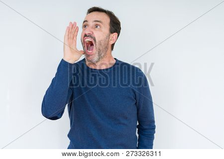 Elegant senior man over isolated background shouting and screaming loud to side with hand on mouth. Communication concept.