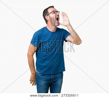 Handsome middle age hoary senior man wearin glasses over isolated background shouting and screaming loud to side with hand on mouth. Communication concept.