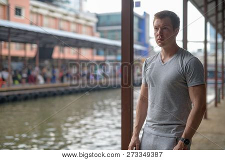 Young Thoughtful Tourist Man Waiting At The Local Pier In Bangkok