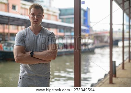 Young Handsome Tourist Man With Arms Crossed At The Local Pier In Bangkok