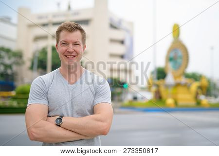Young Happy Tourist Man Smiling Against Ratchadamnoen Street In Bangkok