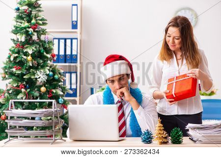 Colleagues exchaing christmas presents in office