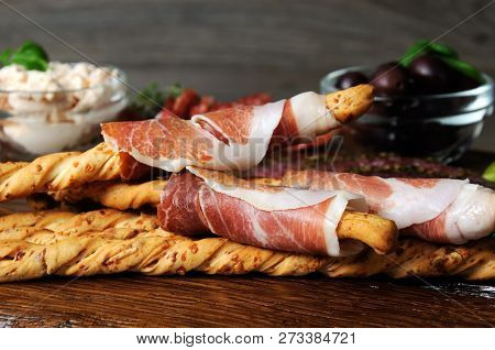 Dish For Antipasto Snacks With Salami, Bread Sticks (grissini) Wrapped With Prosciutto Olives And Ch