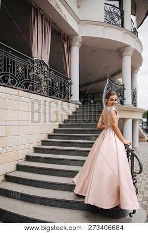 Elegant Lady Satnd On Stairs In Front Of Restaurant
