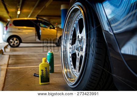 A Bottle Of Polishing Paste Next To A Perfectly Polished Car Disc