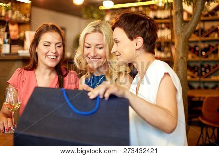 people, leisure and lifestyle concept - women with shopping bags at wine bar or restaurant