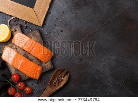 Plastic Container With Fresh Salmon Slice With Oil Tomatoes And Lemon On Stone Kitchen Background