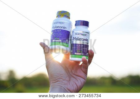 Bangkok,thailand - Dec 11- 2018: Hand Lifting 10 Mg. Melatonin Pills On Sunset Background.melatonin 