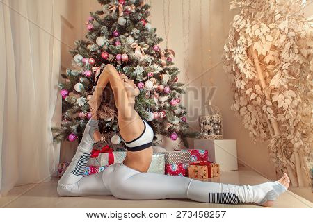 Beautiful Woman Doing Yoga On Christmas Background