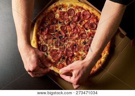 Man's Hand Is Holding Slice Of Double Cheese Pizza From Whole Pizza In A Cardboard Box Dark Table Ba