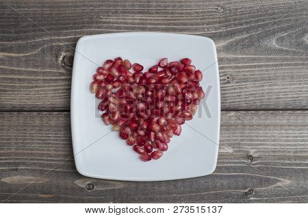 Red Pomegranate Seeds In Shape Of Heart In A Dish