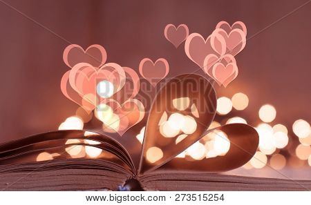 An Open Book With Heart Shaped Pages And Bokeh Lights