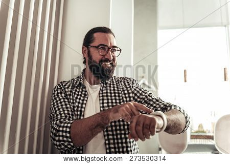 Delighted Bearded Man Pressing A Button On His Watch