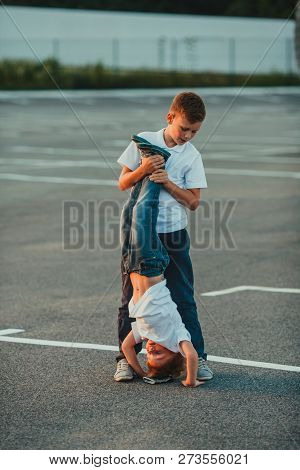 The Boy Standing Upside Down Outdoor In The Summer