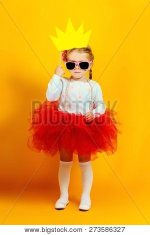 A portrait of a bright young pretty girl in skirt and sunglasses. Summer bright fashion for kids.