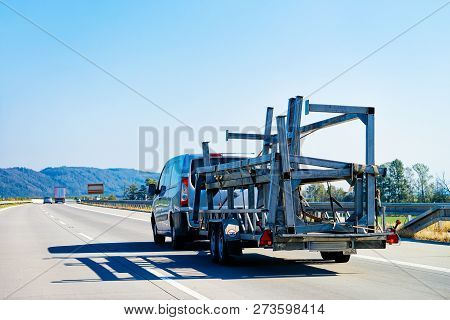 Mini Van Carrying Trailer On The Asphalt Road In Slovenia.