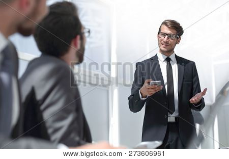 businessman with a smartphone standing in his ofiice