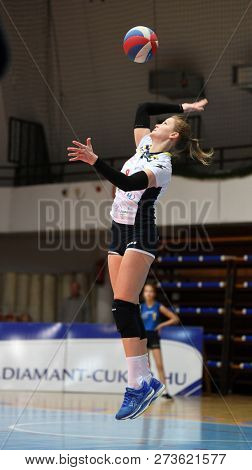 KAPOSVAR, HUNGARY â DECEMBER 2, 2018: Ildiko Szivos serves ball at a Hungarian National Championship volleyball game between Kaposvar (white) and Palota VSN (blue) in Sportcsarnok Kaposvar.