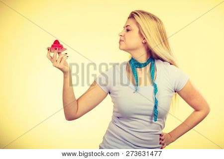 Restrictive Diet, Temptation, Losing Weight Concept. Woman Holding Strawberry Sweet Cupcake Having M