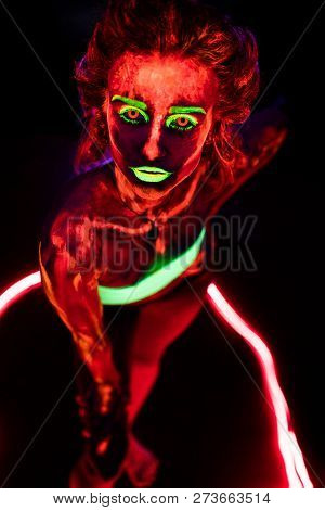 Portrait Of A Beautiful Young Sexy Girl With Ultraviolet Paint On Her Body. Pretty Woman With Glowin