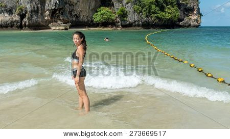 Teen Standing In Water On Tropical Beach Facing Camera