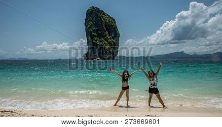 Mother And Daughter Dancing On A Tropical Beach With Island In The Back Ground