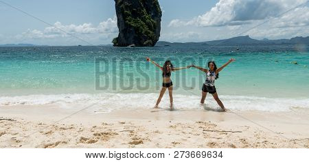 Mother And Daughter Dancing On A Tropical Beach With Island In The Back Ground