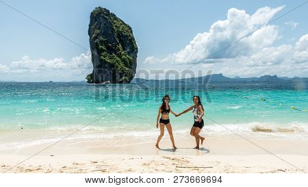 Mother And Daughter Dancing On A Tropical Beach With Island In The Back Ground