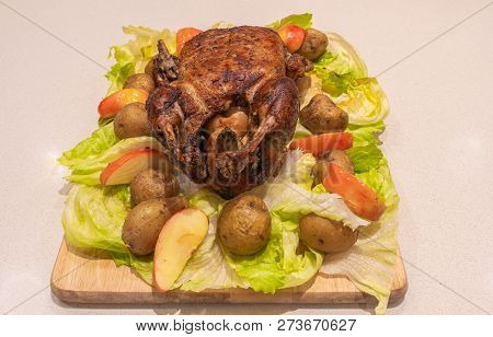 Christmas Goose Whool Roasted And Crispy On The Cutting Board With Roasted Potatoes, Apples And Brus