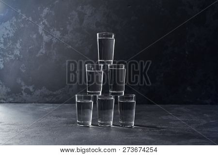 Pyramid Of Glasses Of Vodka On A Black Background, Selective Foc