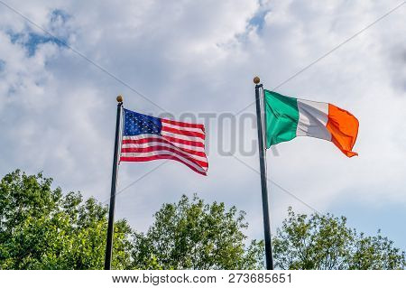 Flags Of United States And Irland Fluttering Against A Blue Sky, Near Rhode Island Irish Famine Memo