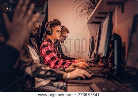 Team Of Teenage Gamers Plays In A Multiplayer Video Game On Pc In A Gaming Club.