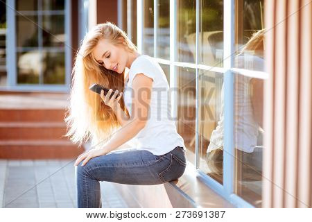 Attractive Smiling Woman Using Smartphone Outdoors. Lefestyle Concept