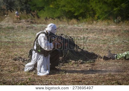 Sambek, Rostov Region, Russia, August 19, 2018: Reconstruction Of Afghan War. Mujahid Sits With A Gu
