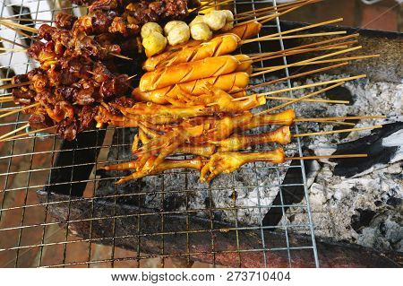 Chicken Feet, Pork Skewers, Sausages And More Cooking On An Outdoor Grill At A Street Food Stall In 