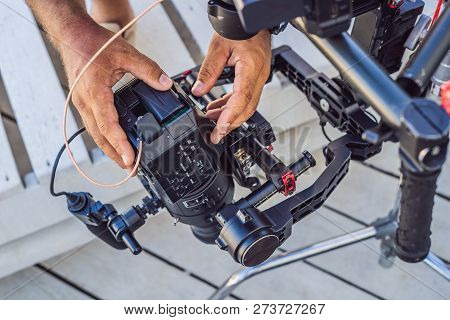 Steadicam Operator And His Assistant Prepare Camera And 3-axis Stabilizer-gimbal For A Commercial Sh