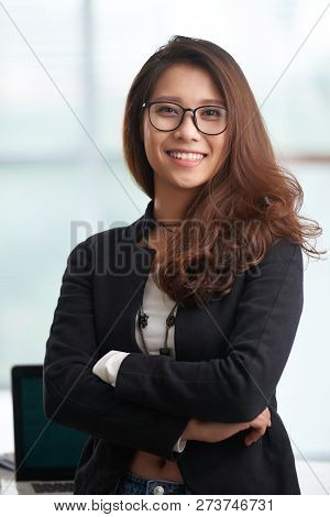 Portrait Of Young Attractive Vietnamse Woman With Beautiful Thick Hair Smiling At Camera