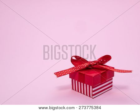Small Red Gift Cardbox With Ribbon And Bow On Pink Background With Copy Space