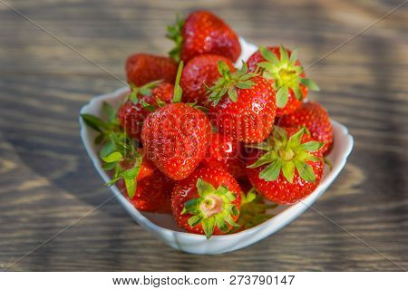 A Small White Porcelain Bowl Filled With Juicy Fresh Ripe Red Strawberries. Textured Table Top. Fres