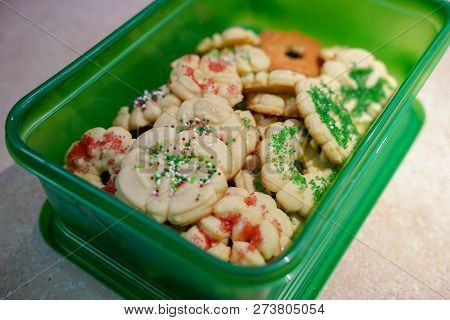 Homemade Butter Spritz Christmas Cookies Packed In A Green Plastic Container For Easy Transport To A
