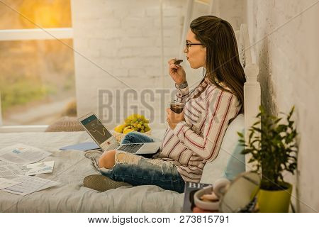 Pregnant Woman Working At Home And Eating A Dessert