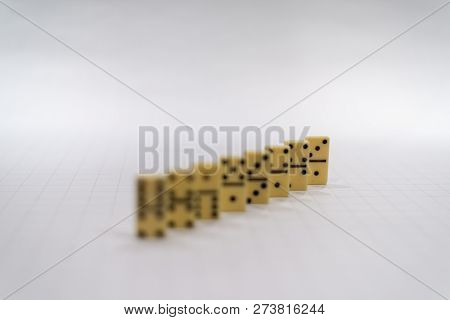 Row Of Yellow Domino Pieces On The White Background With The Last Piece In Focus