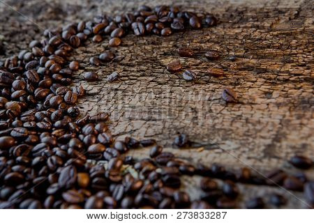 Coffee Beans On Wood Texture Background. Coffee Cup Full Of Coffee Beans.