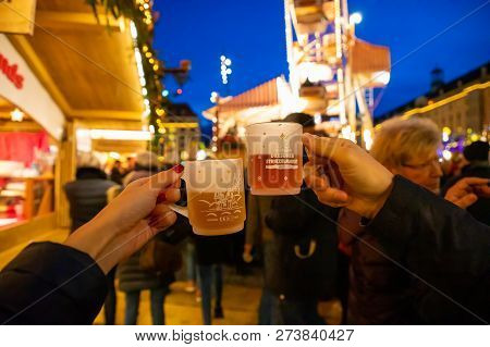 Dresden, Germany - 9.12.2018: Christmas Mugs In People Hands With Christmas Lights On The Background