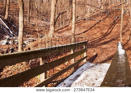 A Wooden Bridge With Snow On It In The Bare Winter Woods In Frick Park, Pittsburgh, Pennsylvania, Us
