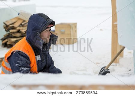 Worker Fitter In A Protective Helmet And Reflective Vest On The Working Meast